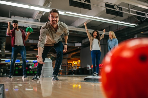 写真 ボウリングボールを投げる魅力的な若い男のショット