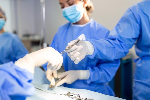 Shot in the Operating Room Assistant Hands out Instruments to Surgeons During Operation Surgeons Perform Operation Professional Medical Doctors Performing Surgery