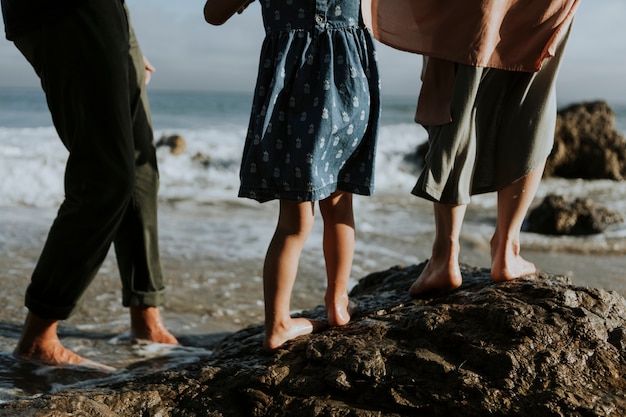 A shot of people feet walking on rocks at the beach