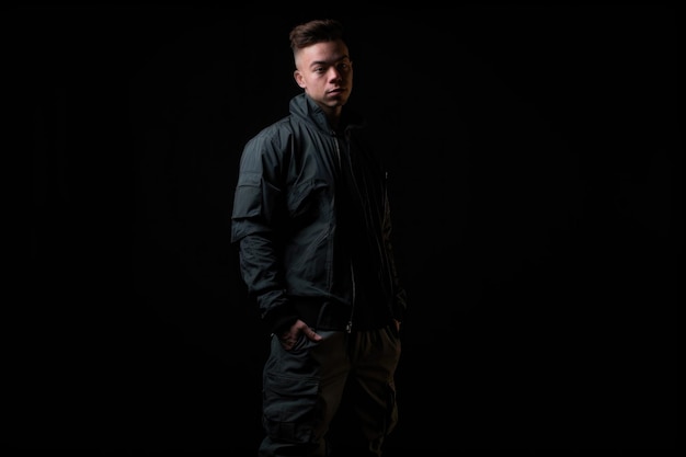 Shot of a person in casual streetwear standing and posing against a dark background