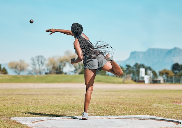Shot put woman and athlete throw in competition championship or training for field event with metal or steel weight Throwing ball or female in athletics sport on outdoor field for olympics
