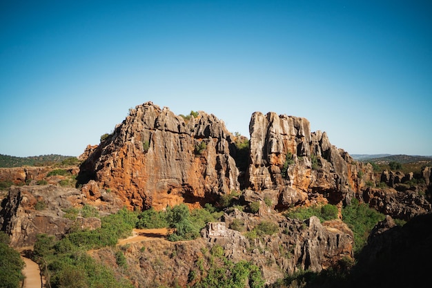 초목 Parque Natural Sierra Norte de Sevilla로 둘러싸인 오후에 바위 산의 샷