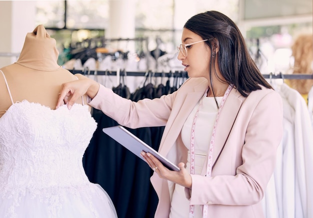 Shot of a seamstress using a digital tablet while working in a boutique