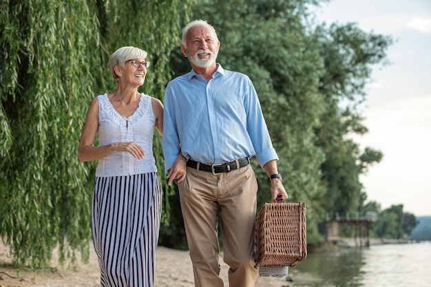 Shot of a senior couple going on a picnic at the riverbank