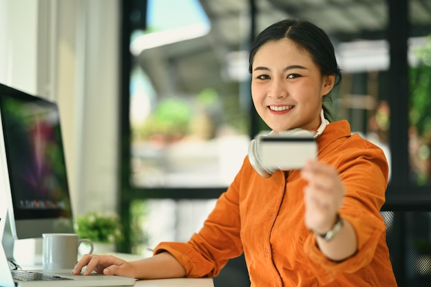 Shot of Shopping online concept Office woman holding credit card and using laptop computer