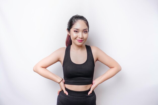 Photo shot of a sporty young confident woman posing against a white background