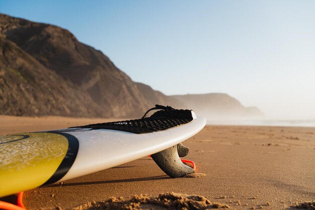 Photo shot of a surfboard on the sand at a portuguese beach cordoama beach