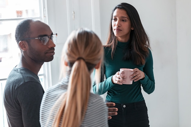 Shot of three young business people drinking coffee while taking a break in the office.