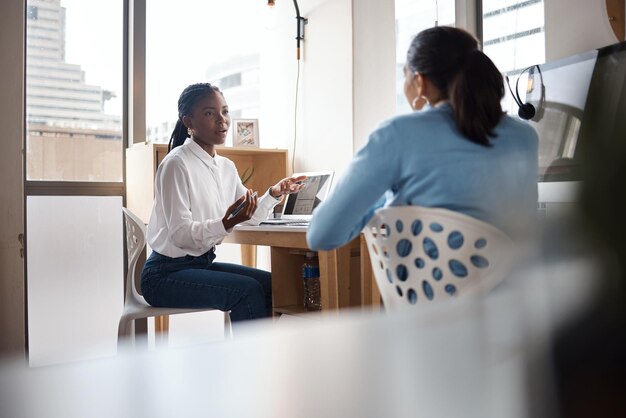 Photo shot of a two young businesswomen having a conversation in a modern office