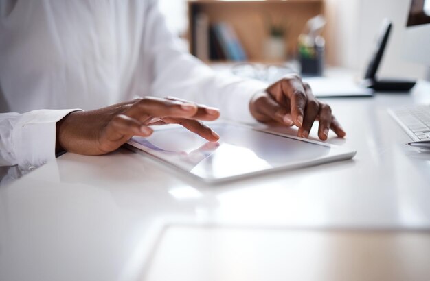 Shot of an unrecognisable businesswoman using a digital tablet at her desk in a modern office