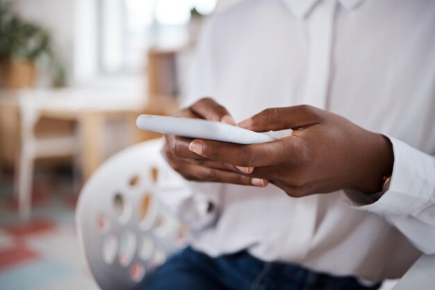 Shot of an unrecognisable businesswoman using a smartphone in a modern office