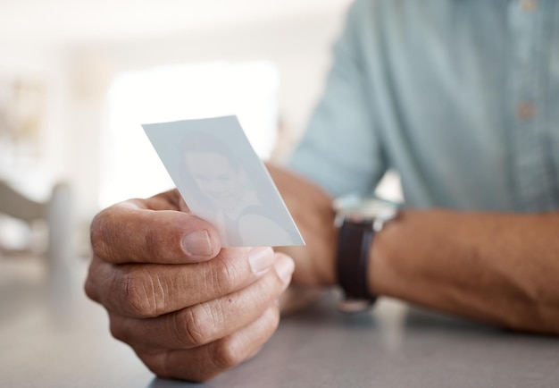 Shot of an unrecognizable person holding a photo at home