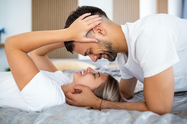 Shot van een aanhankelijk jong stel dat een romantisch moment deelt in de slaapkamer thuis