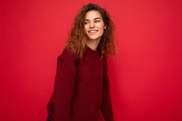 Shot van een aantrekkelijke, gelukkig lachende jonge vrouw die een casual outfit draagt, geïsoleerd over kleurrijk