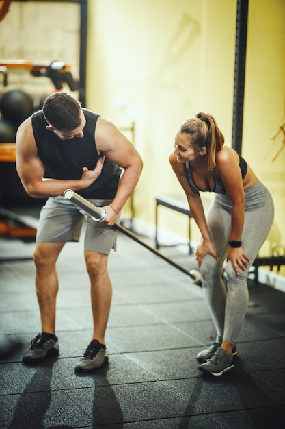 Shot van een aantrekkelijke jonge vrouw die traint met een personal trainer in de sportschool.