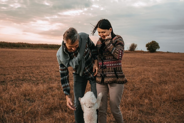 Shot van een echtpaar van middelbare leeftijd dat geniet van een dag in de natuur met hun hond