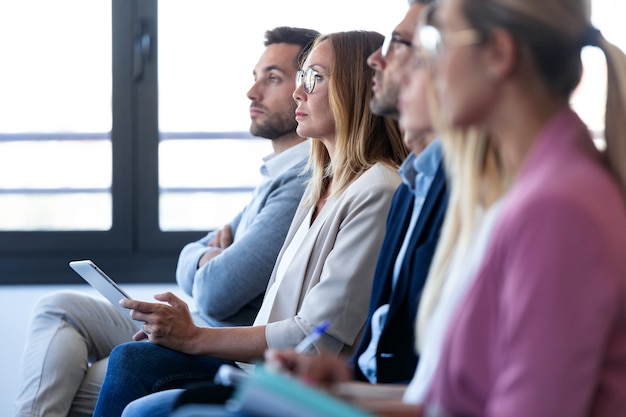 Foto shot van een geconcentreerd business team dat oplet tijdens een conferentie over een coworking-plek.