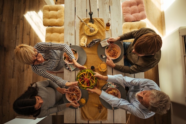 Foto shot van een gezin dat thuis luncht in de keuken. uitzicht van boven