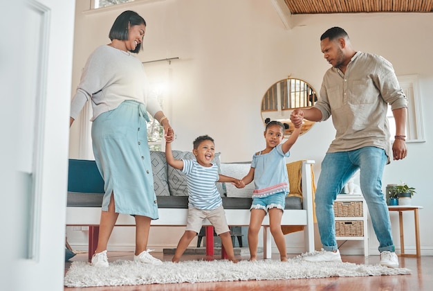 Shot van een jonge familie die zich hecht terwijl ze samen danst in de lounge thuis