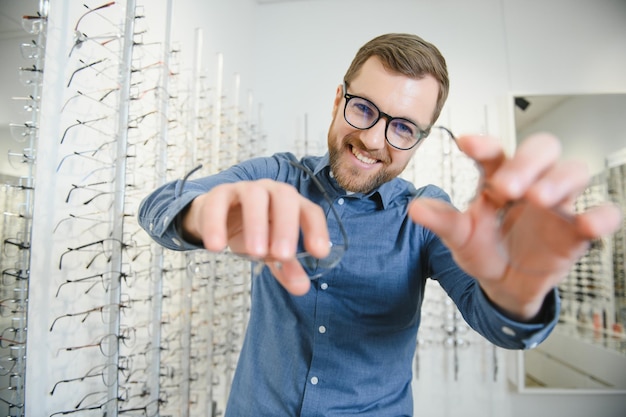 Foto shot van een knappe man met een baard die een nieuwe bril probeert in de brillenwinkelman die een bril kooptgezondheid gezichtsvermogen visie mode winkelen