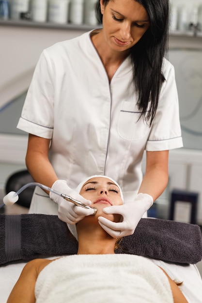 Shot van een mooie jonge vrouw op een gezichtsbehandeling met microdermabrasie in de schoonheidssalon.