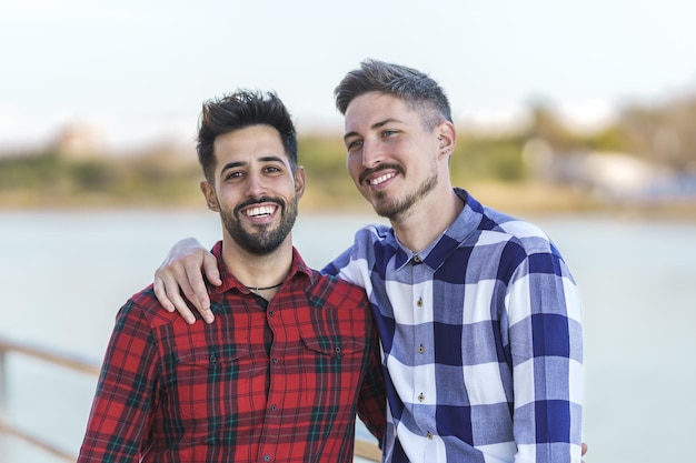 Shot vanuit een gemiddeld perspectief van een portret van een homostel dat elkaar omhelst bij een rivier