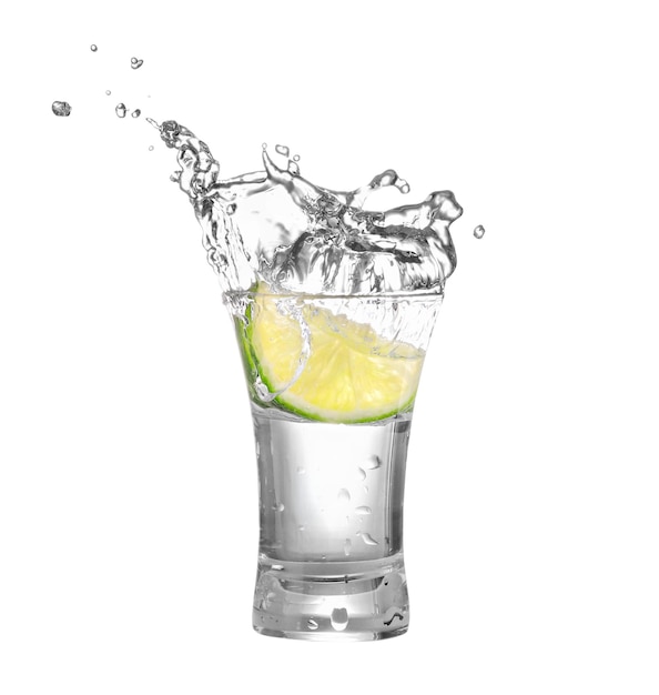 shot of vodka or tequila with lime slice and splash isolated on white background