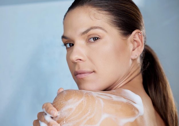 Photo shot of a woman washing herself against a grey background