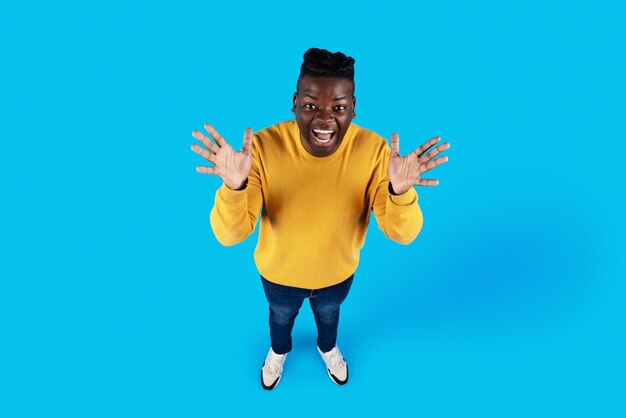 Above Shot Of Young African American Man Spreading Hands With Excitement