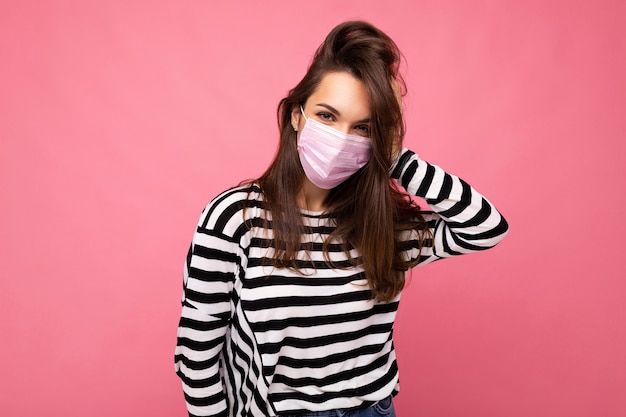 Shot of young attractive woman wearing mediacal face mask isolated over wall wall protection