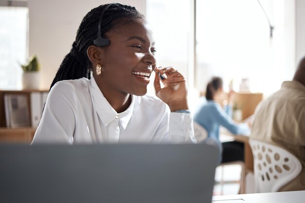 Shot of a young businesswoman using a headset and laptop in a modern office