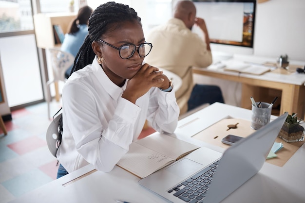 Photo shot of a young businesswoman using a laptop in a modern office