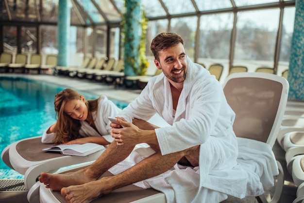 Photo shot of a young couple by the pool at a spa