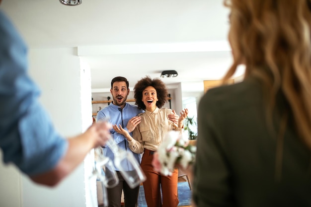 Foto inquadratura di una giovane coppia che accoglie gli amici nella loro nuova casa