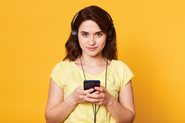 Shot of young dark haired girl with earphones, ready to listen to music