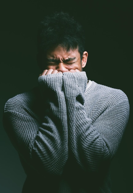 Shot of a young man looking nervous against a dark background