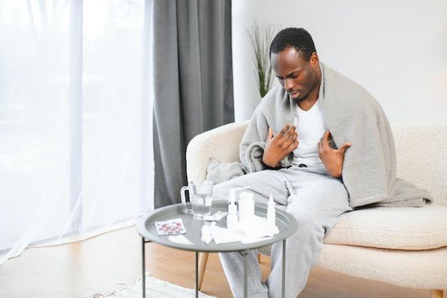 Shot of a young man with a cold recuperating at home