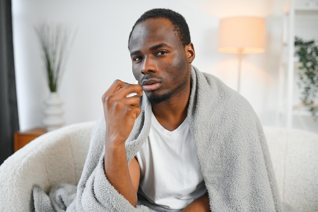 Photo shot of a young man with a cold recuperating at home