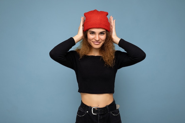 Shot of young nice winsome brunet woman wavyhaired with sincere emotions wearing black crop top and