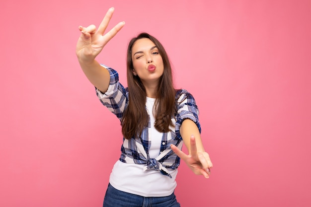 Shot of young positive delightful smiling pretty brunette woman with sincere emotions wearing