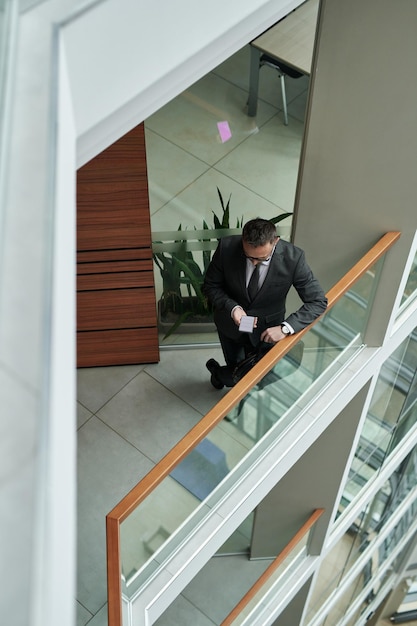 Above shot of young welldressed businessman texting in smartphone