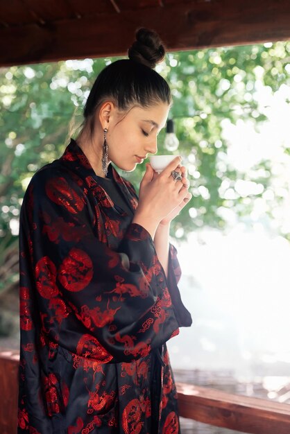 Shot of young woman drinking from tea bowl