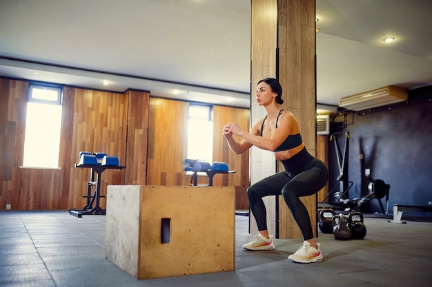 Photo shot of young woman working out with a box at the gym