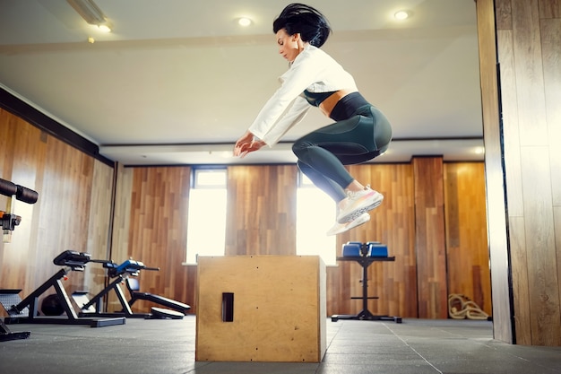 Shot of young woman working out with a box at the gym