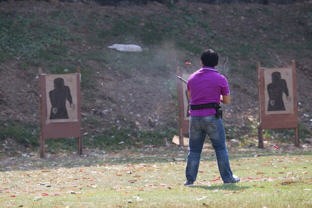 Shoter shooting  gun on an outdoor shooting range, selective focus