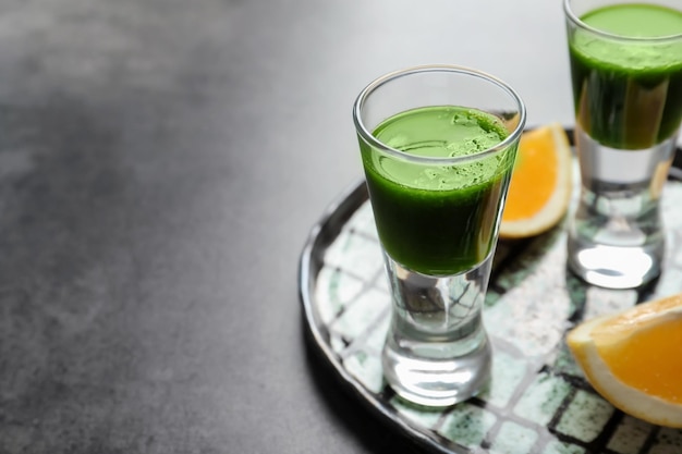 Shots of healthy wheat grass juice on plate