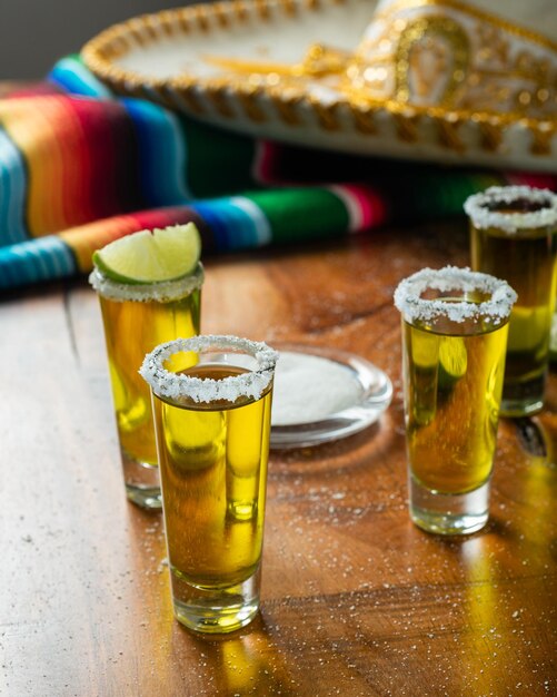Shots tequila met zout en citroen op een houten tafel feestelijke achtergrond