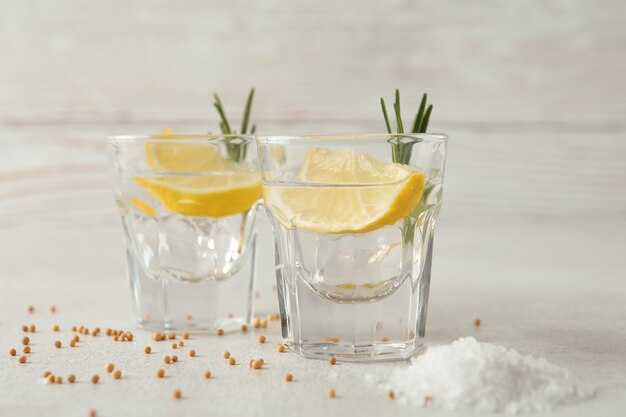 Shots of tequila on white textured table