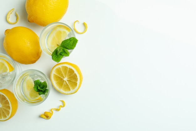 Shots of vodka and lemons on white background