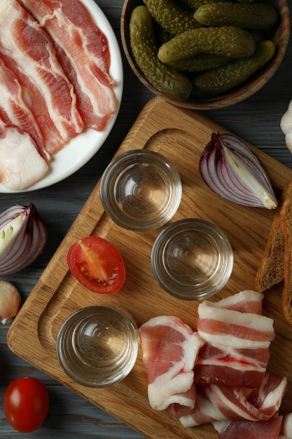 Shots of vodka and tasty snacks, top view